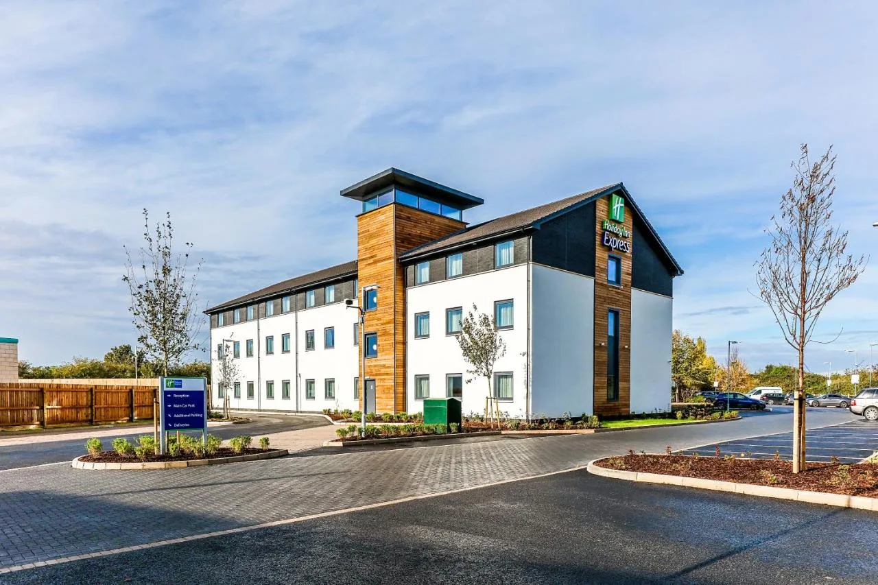 a large white building with a black roof at Holiday Inn Express Cambridge by IHG in Cambridge