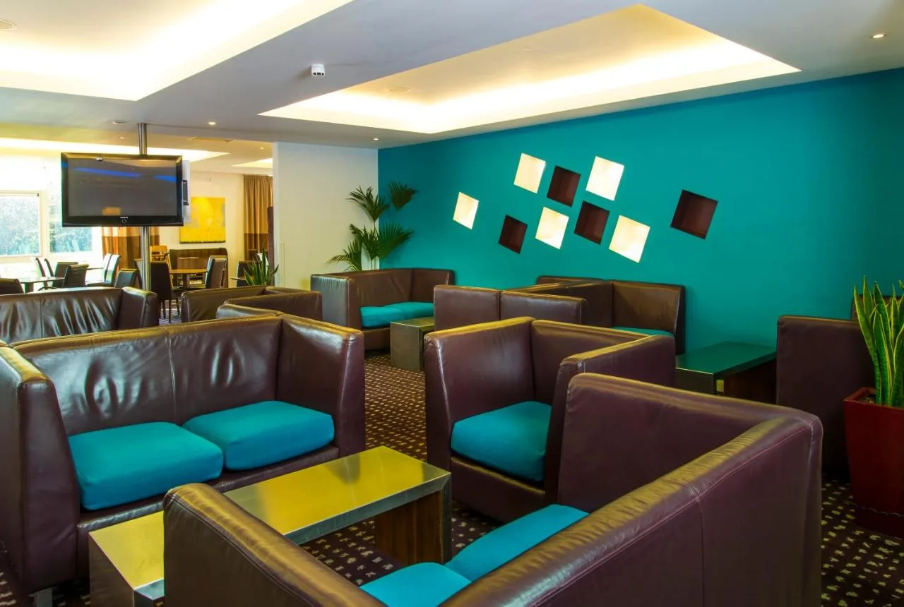 a waiting room with leather chairs and a flat screen tv at Holiday Inn Express Cambridge by IHG in Cambridge