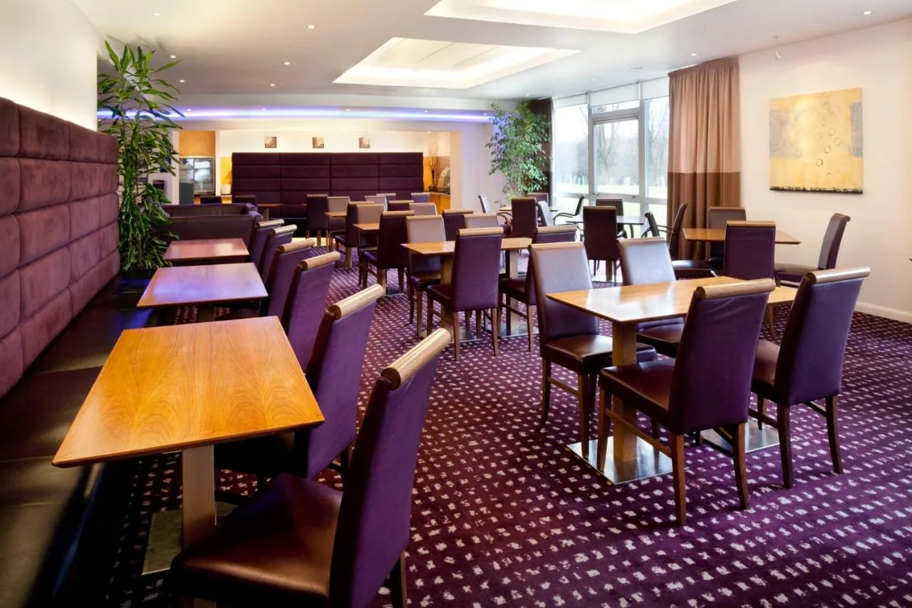a dining room with wooden tables and chairs at Holiday Inn Express Cambridge by IHG in Cambridge
