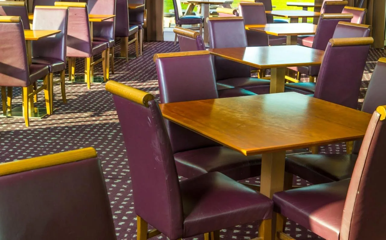 an empty restaurant with tables and chairs at Holiday Inn Express Cambridge by IHG in Cambridge